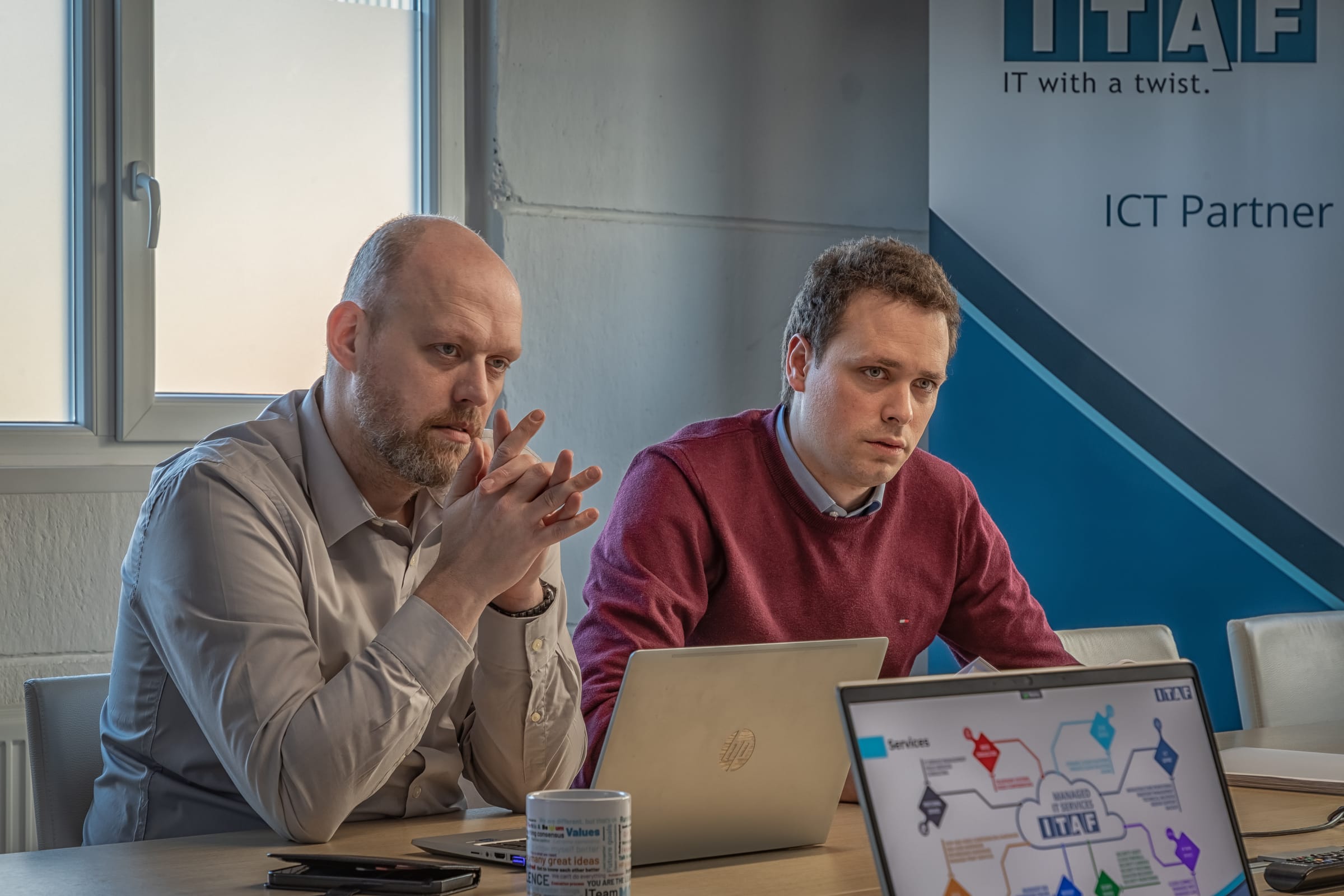 Vergaderzaal met laptops en een scherm